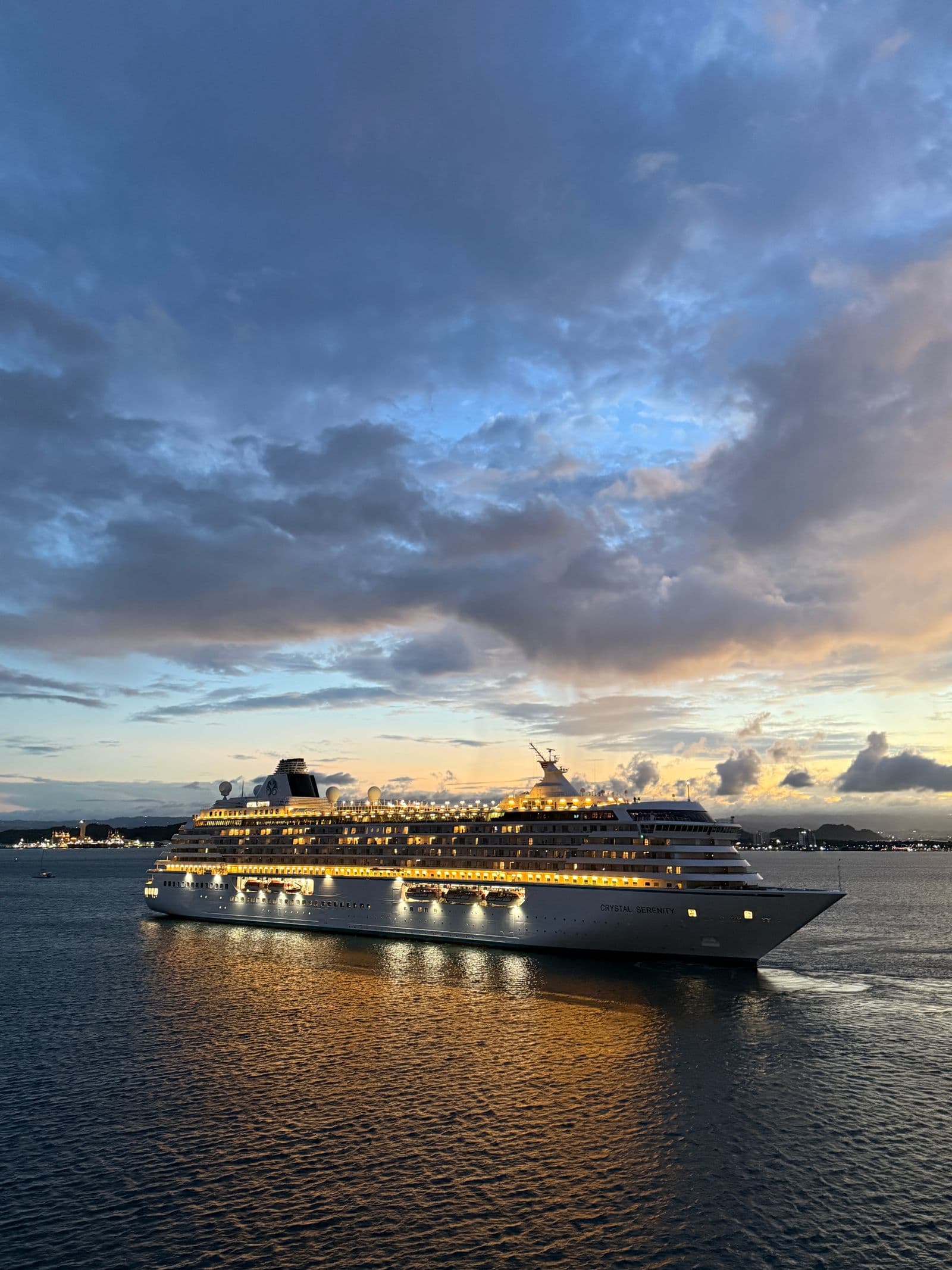 A cruise ship lit up against an evening sky